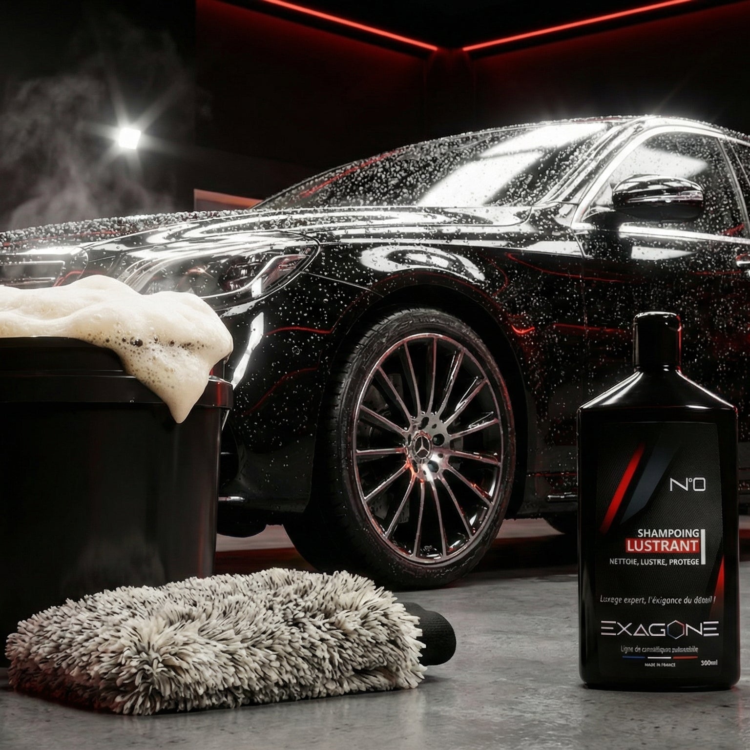 Shampoing lustrant EXAGONE N°0 pour lavage automobile avec mousse active, seau et gant de lavage devant véhicule noir brillant